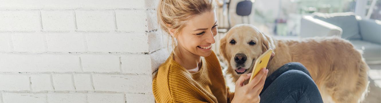 girl looking at her phone with dog zelle