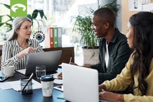 couple at a table with a laptop sitting and talking with a financial advisor