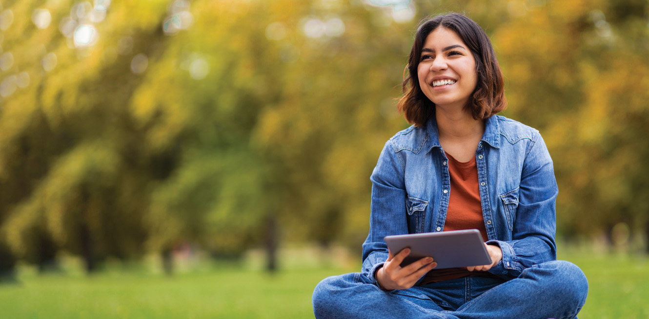 homepage banner - woman outside holding tablet and smiling